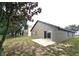 Backyard view featuring a patio area and sliding glass door, surrounded by green grass at 928 Chanler Dr, Haines City, FL 33844