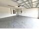 Spacious garage with concrete flooring and block walls, equipped with a garage door opener at 928 Chanler Dr, Haines City, FL 33844