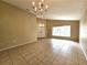 Living room with a chandelier, tile floors, and a view of the front door and front yard at 928 Chanler Dr, Haines City, FL 33844
