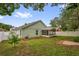 Home featuring a spacious green backyard with a screened patio and white vinyl fence at 9871 Nonacrest Dr, Orlando, FL 32832