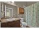 Bathroom featuring a vanity, toilet, and green floral shower curtain at 9871 Nonacrest Dr, Orlando, FL 32832