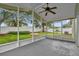 Covered and screened patio with ceiling fan overlooking a manicured lawn and white vinyl fence at 9871 Nonacrest Dr, Orlando, FL 32832