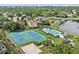 The aerial view features two tennis courts, a pool, and manicured landscaping by a lake at 10030 Chatham Oaks Ct, Orlando, FL 32836