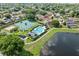 Aerial view features a lake, two tennis courts, a pool, and manicured landscaping at 10030 Chatham Oaks Ct, Orlando, FL 32836