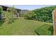 An image of a grassy backyard showing some shade and adjacent privacy landscaping at 10030 Chatham Oaks Ct, Orlando, FL 32836