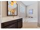 Bathroom showing a white garden tub, vanity with white countertops, and framed mirror at 10030 Chatham Oaks Ct, Orlando, FL 32836