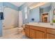 Bathroom showcasing blue walls, vanity with white countertop, a tub, and a window at 10030 Chatham Oaks Ct, Orlando, FL 32836