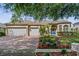 Charming single-Gathering home showcasing a well-manicured front yard, brick driveway, and a three-car garage at 10030 Chatham Oaks Ct, Orlando, FL 32836