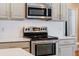 Close-up of a stainless steel range oven, microwave and stylish countertops in a modern kitchen at 10030 Chatham Oaks Ct, Orlando, FL 32836