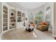 Inviting sitting room with built-in bookshelves, carpeted floors, and large windows with natural light at 10030 Chatham Oaks Ct, Orlando, FL 32836