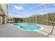 A kidney-shaped pool is surrounded by a screened enclosure with lush landscaping for privacy at 10030 Chatham Oaks Ct, Orlando, FL 32836