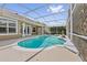 The screened-in kidney-shaped pool has a concrete deck and is adjacent to the home at 10030 Chatham Oaks Ct, Orlando, FL 32836