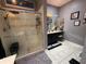 Stylish bathroom featuring double vanity sinks, framed mirrors, and a glass-enclosed shower at 10075 Sw 91St Pl, Ocala, FL 34481