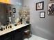 Bathroom vanity with a double sink, vanity lighting, shelves, mirror, and stylish decor at 10075 Sw 91St Pl, Ocala, FL 34481