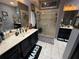 Stylish bathroom featuring double vanity sinks, framed mirrors, and a glass-enclosed shower at 10075 Sw 91St Pl, Ocala, FL 34481