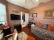 Cozy bedroom with hardwood floors, daybed, TV, and a door leading to another room at 10075 Sw 91St Pl, Ocala, FL 34481