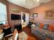 Cozy bedroom with hardwood floors, daybed, TV, and a door leading to another room at 10075 Sw 91St Pl, Ocala, FL 34481