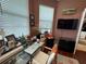 This bedroom features a desk, TV, hardwood floors, and a door leading to another room at 10075 Sw 91St Pl, Ocala, FL 34481