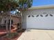 Attached two-car garage of a home featuring decorative windows and a concrete driveway at 10075 Sw 91St Pl, Ocala, FL 34481