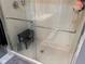 Walk-in shower with glass doors, a shower bench, and sleek fixtures at 10075 Sw 91St Pl, Ocala, FL 34481