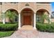 Charming front entrance with arched columns, a decorative wood door, and manicured landscaping at 1010 Terrace Blvd, Orlando, FL 32803
