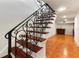 Elegant staircase featuring decorative wrought iron railing and wood steps, leading to a brightly lit landing with terracotta tile flooring at 1010 Terrace Blvd, Orlando, FL 32803