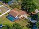 Aerial view of a home with a screened-in pool, landscaping, long driveway, and mature trees at 10545 Parkway Dr, Clermont, FL 34711