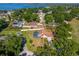Aerial view of a home with a screened-in pool, manicured lawn and mature trees near a lake at 10545 Parkway Dr, Clermont, FL 34711