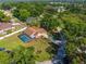 Aerial view of a home with a screened-in pool, landscaping, and a long driveway surrounded by mature trees at 10545 Parkway Dr, Clermont, FL 34711