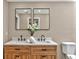 Bathroom vanity with double sinks, wood cabinets, black hardware and a floral arrangement at 10545 Parkway Dr, Clermont, FL 34711
