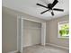 Bedroom featuring a ceiling fan, window and closet with folding doors at 10545 Parkway Dr, Clermont, FL 34711