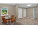 Cozy dining area with a glass table and comfortable chairs, featuring a window with lush outdoor views at 10545 Parkway Dr, Clermont, FL 34711