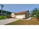 Brick home featuring a well-kept lawn, attached two car garage, and mature landscaping at 10545 Parkway Dr, Clermont, FL 34711