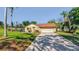 Charming single-story brick home with a manicured lawn and lush tropical landscaping at 10545 Parkway Dr, Clermont, FL 34711