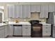 Modern kitchen features gray cabinets, stainless steel appliances, and a beautiful marble countertop at 10545 Parkway Dr, Clermont, FL 34711