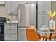 Modern kitchen featuring a stainless steel refrigerator and gray cabinets, next to an adjacent dining area at 10545 Parkway Dr, Clermont, FL 34711
