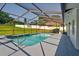Relaxing screened-in pool area with cool blue water, mosaic waterline, and lush landscaping at 10545 Parkway Dr, Clermont, FL 34711