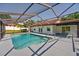 Enclosed swimming pool area surrounded by gray concrete deck and a screened enclosure at 10545 Parkway Dr, Clermont, FL 34711