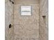Modern tiled shower featuring bronze fixtures, a window, and a convenient inset shelf at 10545 Parkway Dr, Clermont, FL 34711