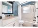Bathroom with blue walls, white cabinets, updated hardware, and shower/tub combo at 11900 Frieth Dr, Orlando, FL 32837