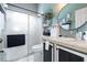 Bathroom with tiled countertop, black hardware, large framed mirror and shower at 11900 Frieth Dr, Orlando, FL 32837