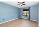 Empty bedroom featuring neutral tile, ceiling fan, and window with curtains at 11900 Frieth Dr, Orlando, FL 32837