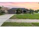 Charming single-story home with a well-manicured lawn and inviting curb appeal under a colorful sky at 11900 Frieth Dr, Orlando, FL 32837