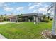Landscaped front yard with mature trees and a charming home with a gray roof and neutral colored paint at 11900 Frieth Dr, Orlando, FL 32837