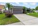 Inviting home with a two car garage, well-manicured lawn, trees and sidewalk leading to front door at 11900 Frieth Dr, Orlando, FL 32837