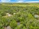 Expansive aerial view of a home surrounded by dense trees and some swimming pools at 12046 Se 135Th Ave, Ocklawaha, FL 32179
