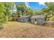 Spacious backyard with mature trees and a partial view of the back side of the home at 12046 Se 135Th Ave, Ocklawaha, FL 32179