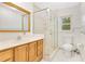 Bathroom features a vanity, a glass enclosed shower, a commode, and a window for natural light at 12046 Se 135Th Ave, Ocklawaha, FL 32179