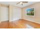 This bedroom features hardwood floors, a window, a ceiling fan and closet with louvered doors at 12046 Se 135Th Ave, Ocklawaha, FL 32179