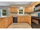 Functional kitchen featuring wooden cabinets, a black appliance suite, and light countertops at 12046 Se 135Th Ave, Ocklawaha, FL 32179